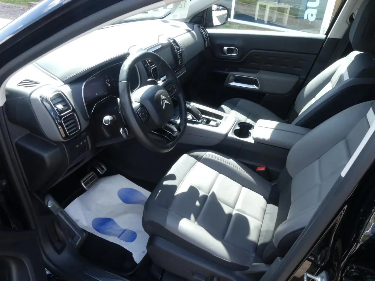 Intérieur avant droit du Citroën C5 Aircross noir, sièges cuir gris, volant multifonction et console centrale avec boîte auto.
