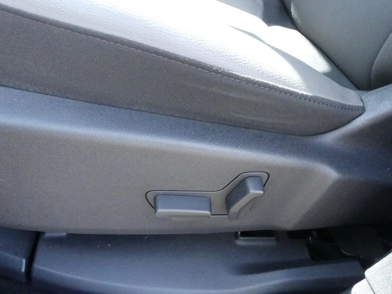 Détail des commandes de réglage manuel du siège avant en tissu gris du Citroën C5 Aircross noir.