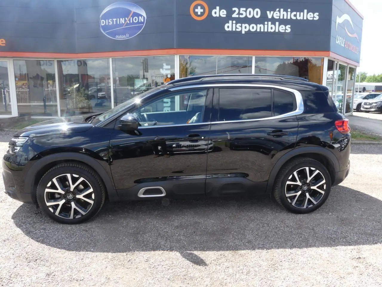 Profil côté gauche du SUV Citroën C5 Aircross noir nacré avec jantes alliage et contours de vitres chromés.