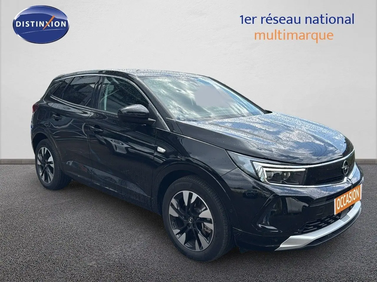 Opel Grandland noir en 3/4 avant droit, SUV hybride rechargeable avec jantes bi-ton et calandre chromée.