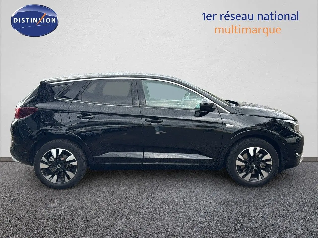 Vue latérale droite d’un Opel Grandland noir 2024 hybride rechargeable avec jantes bi-ton et vitres teintées.