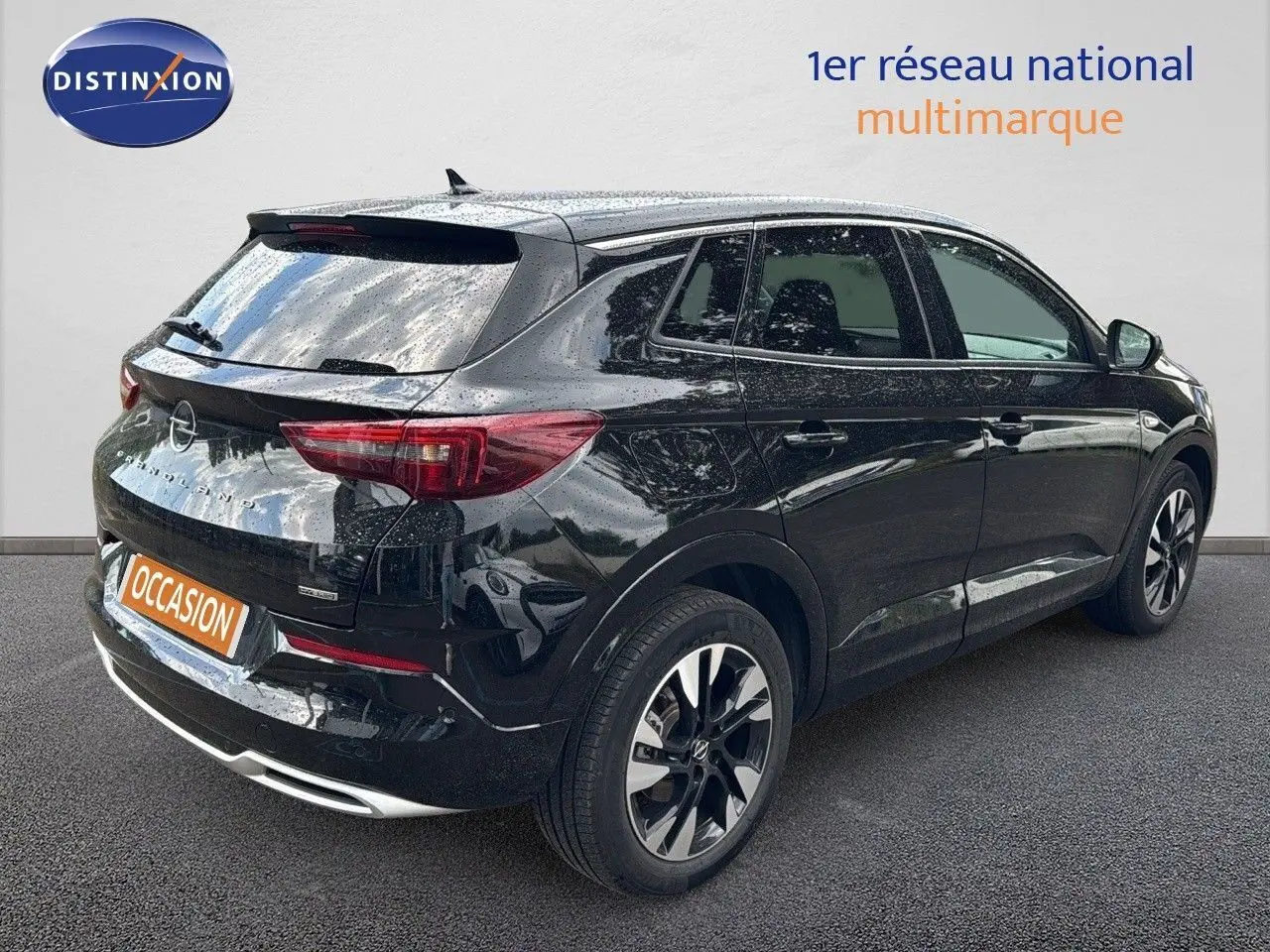Vue 3/4 arrière droite d’un Opel Grandland noir 2024 hybride rechargeable avec jantes bi-ton et feux LED.