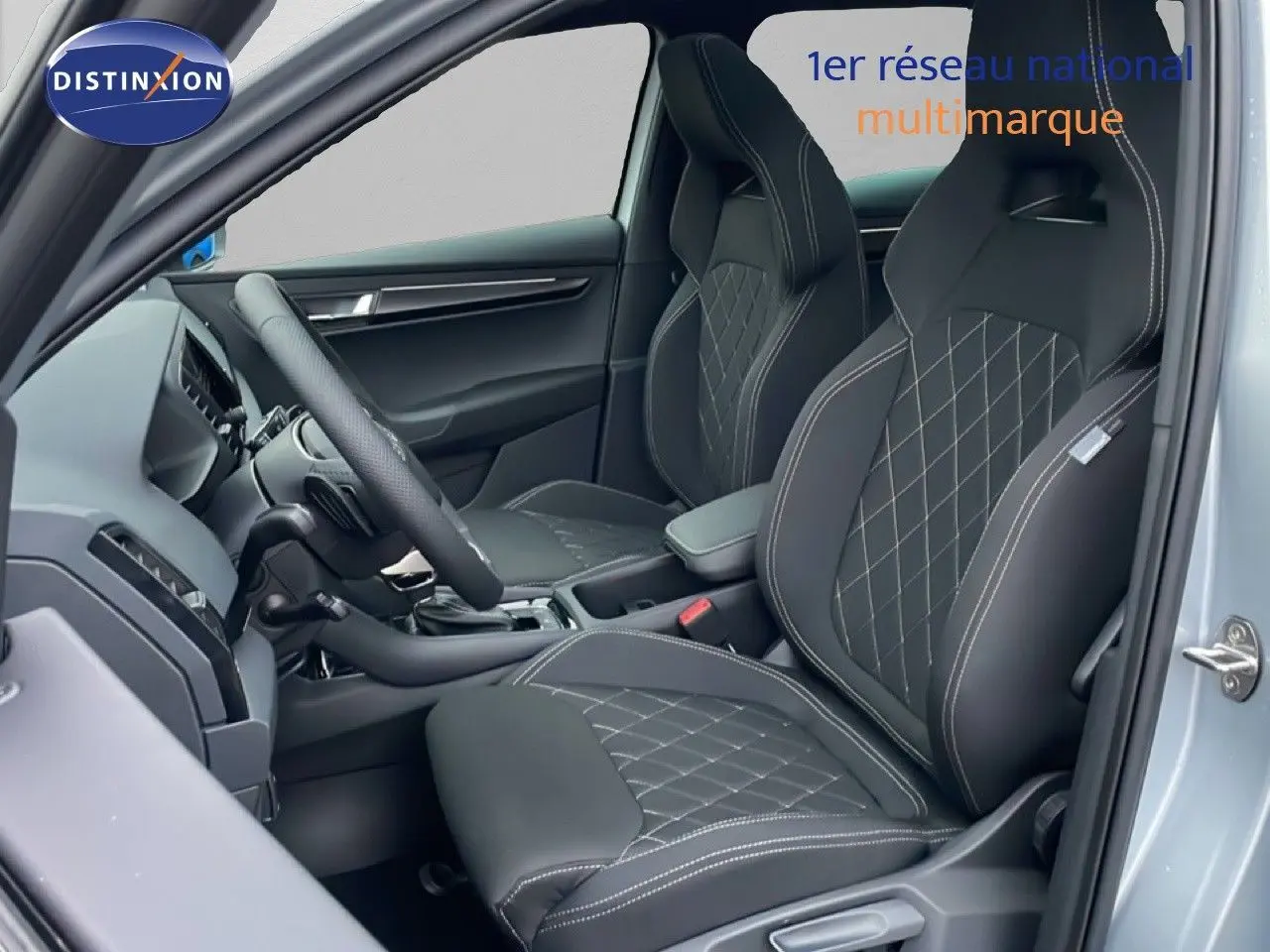 Vue intérieure côté gauche du Skoda Karoq gris argent, mettant en valeur les sièges sport noirs avec surpiqûres contrastantes.