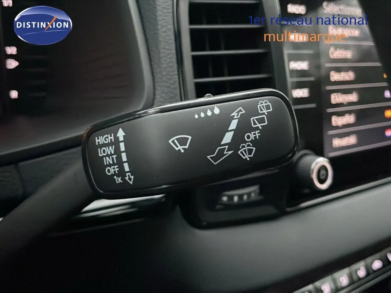 Gros plan sur la commande d’essuie-glace du Skoda Karoq 2025, intérieur noir avec écran tactile en arrière-plan.