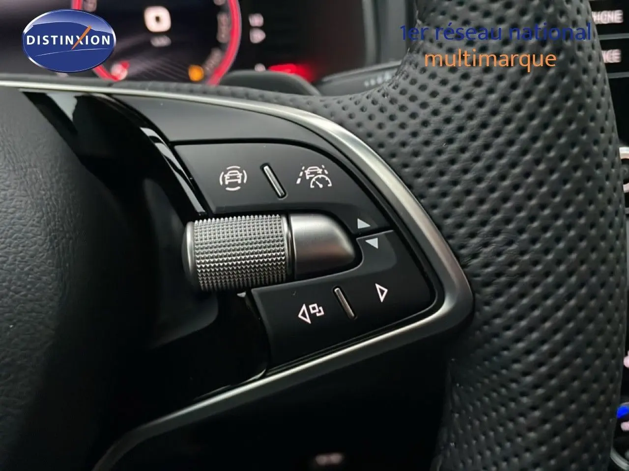 Gros plan sur les commandes multifonctions en aluminium brossé du volant perforé noir d’un Skoda Karoq gris argent 2025.