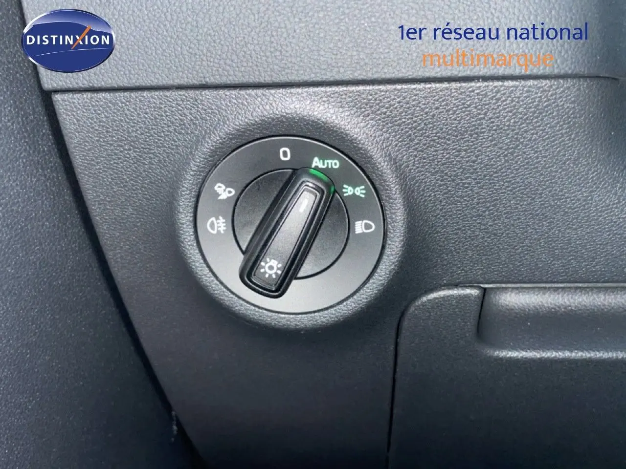 Détail du commutateur des phares sur tableau de bord noir du Skoda Karoq gris argent 2025.