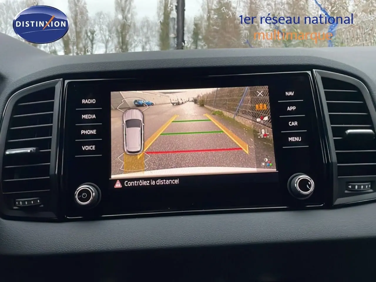 Écran central de la Skoda Karoq 2025 gris argent, vue de la caméra de recul avec guidage de trajectoire.