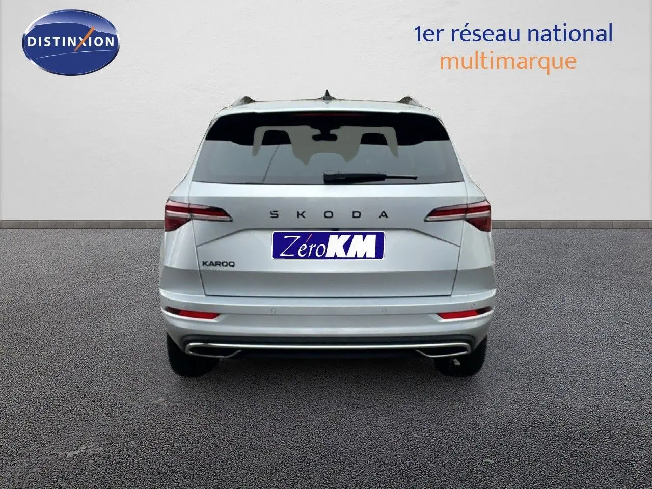 Vue arrière d'un Skoda Karoq gris argent métal 2025, avec feux LED et double sortie d'échappement intégrée.