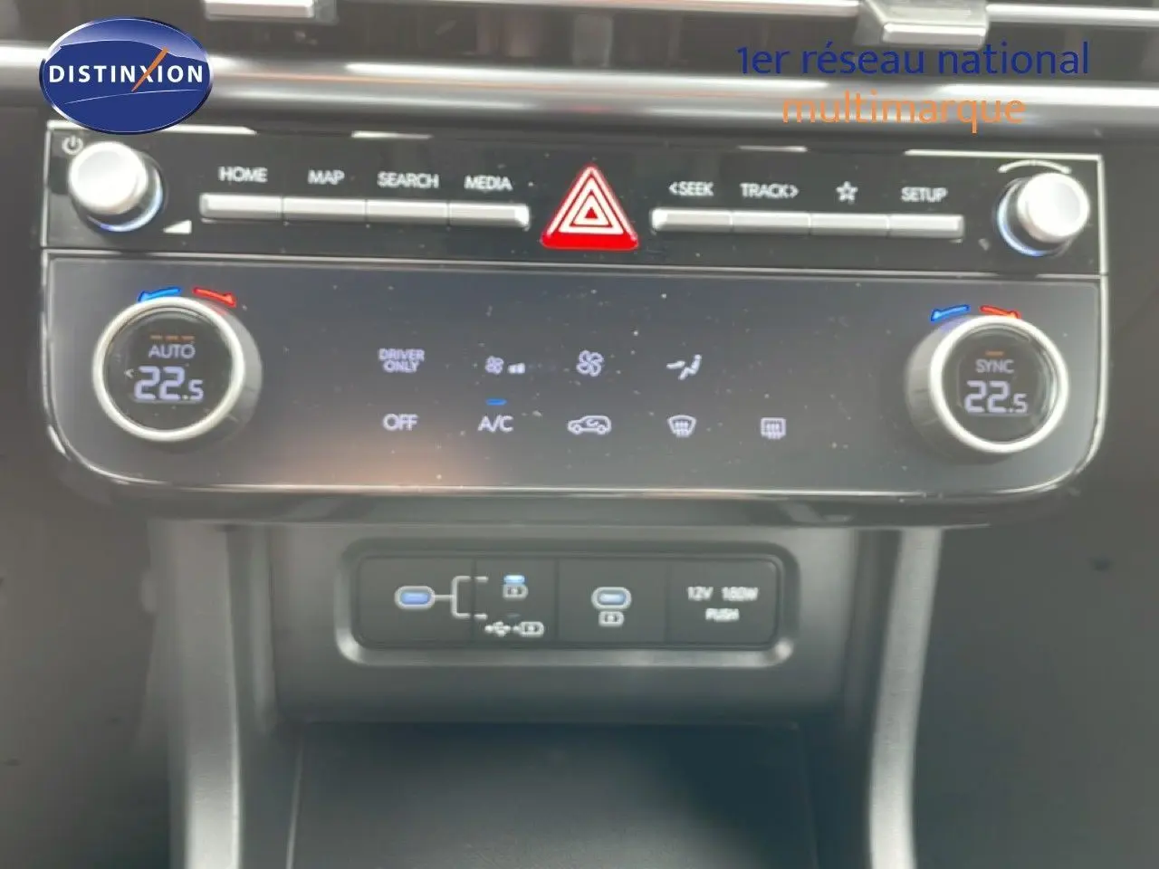 Tableau de bord du Hyundai Tucson blanc Atlas 2026, vue rapprochée sur la console centrale avec commandes climatisation et ports USB.