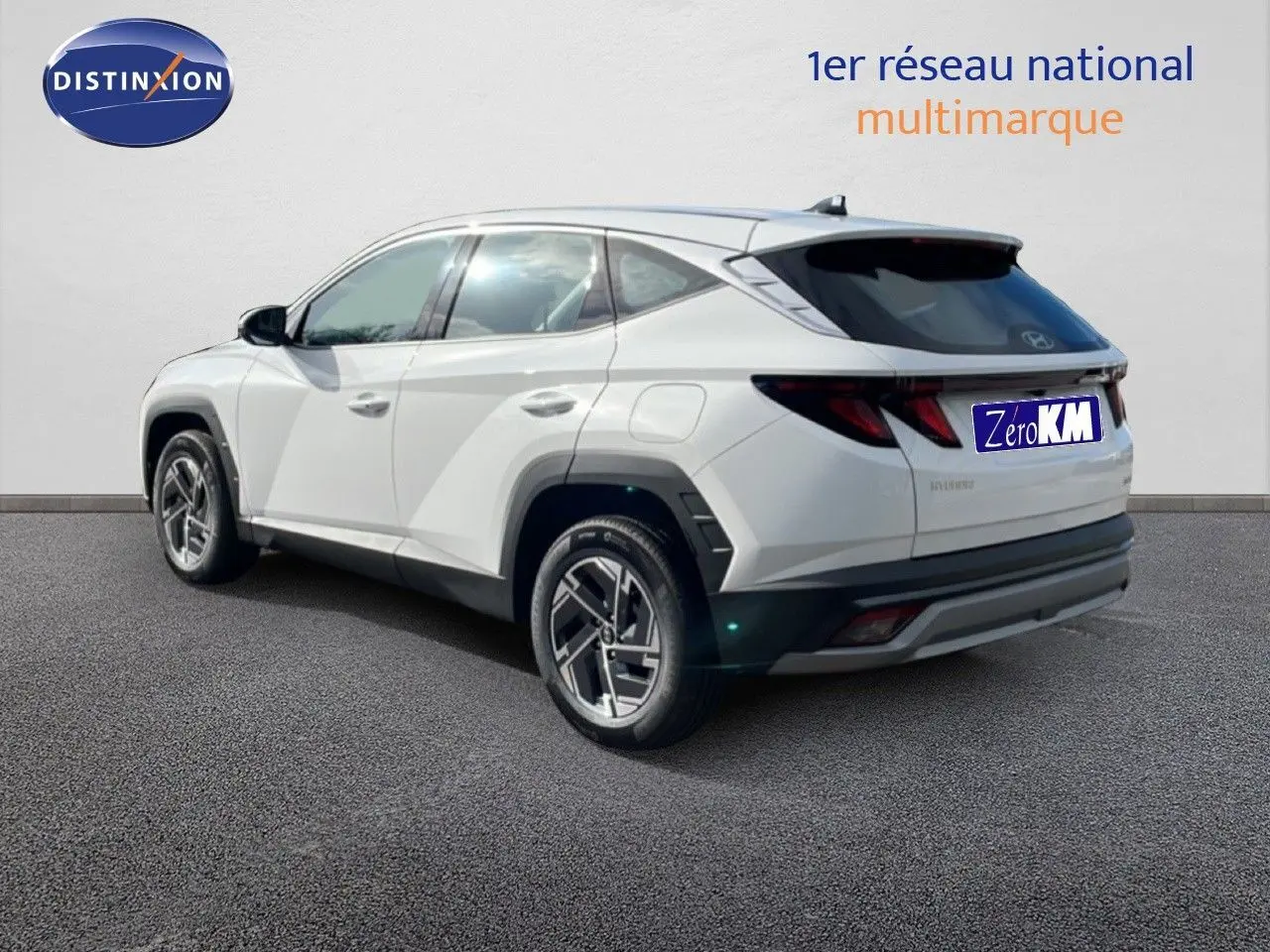 Vue 3/4 arrière droite d’un Hyundai Tucson blanc Atlas 2026 avec jantes bi-ton et feux LED distinctifs.