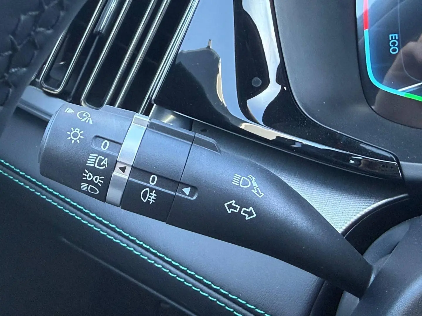 Gros plan sur la manette de clignotants noire avec surpiqûres vertes dans l’habitacle du BYD SEAL U 2026.