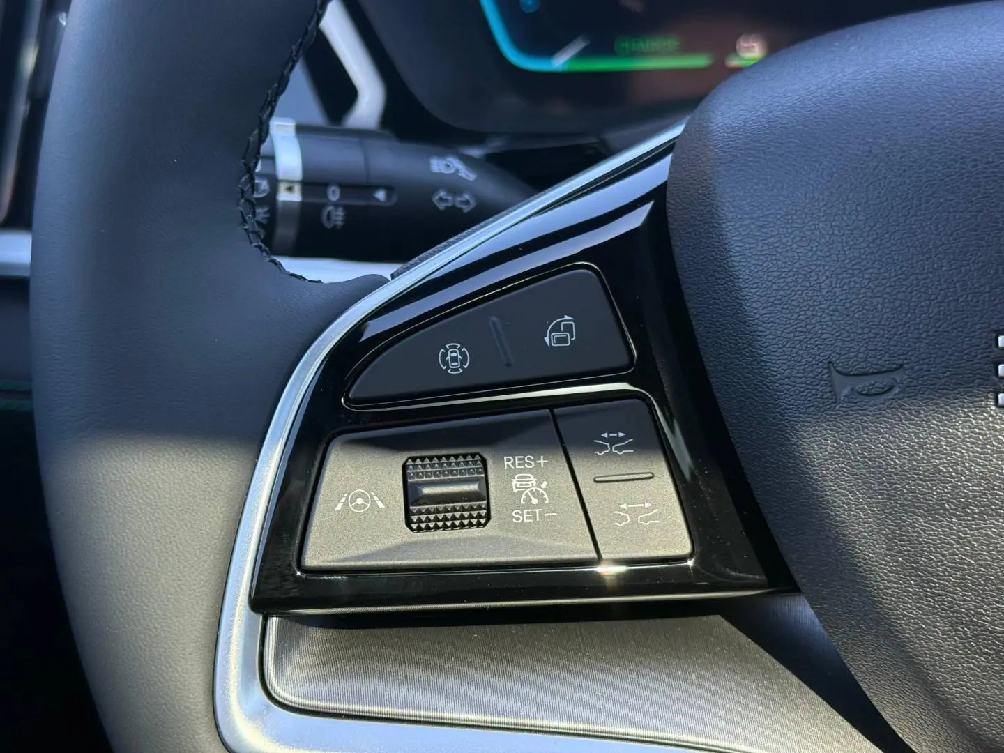 Gros plan sur les commandes du volant noir du BYD SEAL U 1.5 DM-i, avec boutons de régulateur et assistance.