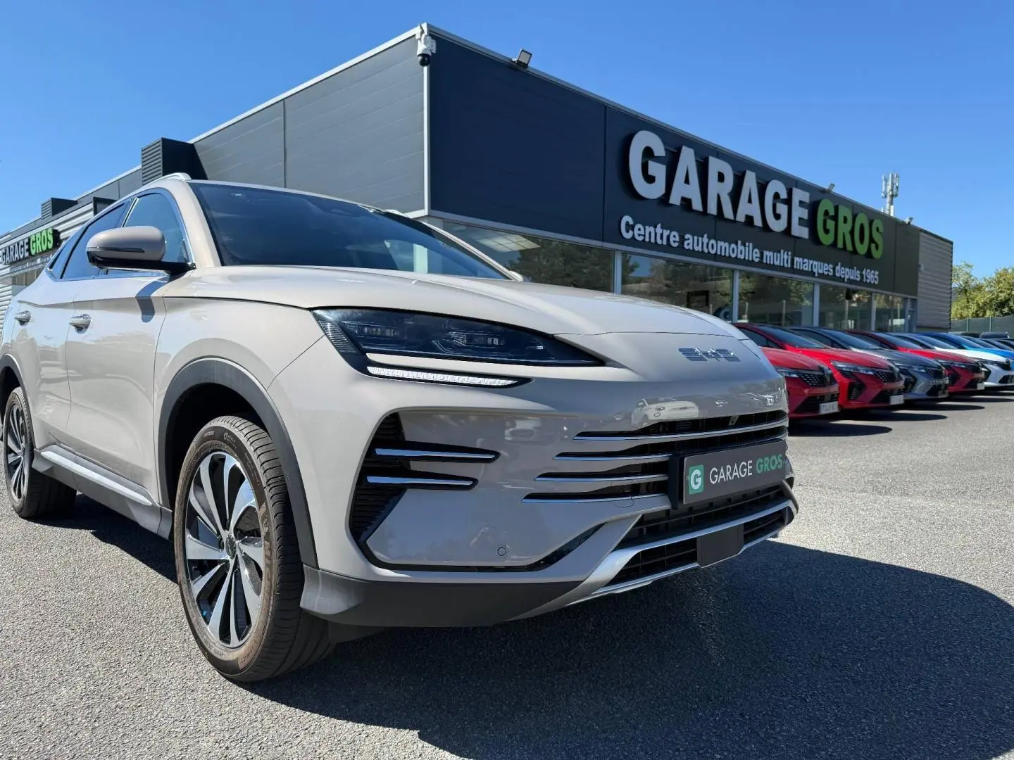Vue 3/4 avant gauche du BYD SEAL U 1.5 DM-i 218ch Boost en Boundless Cloud métallisé avec jantes alu, devant un garage.