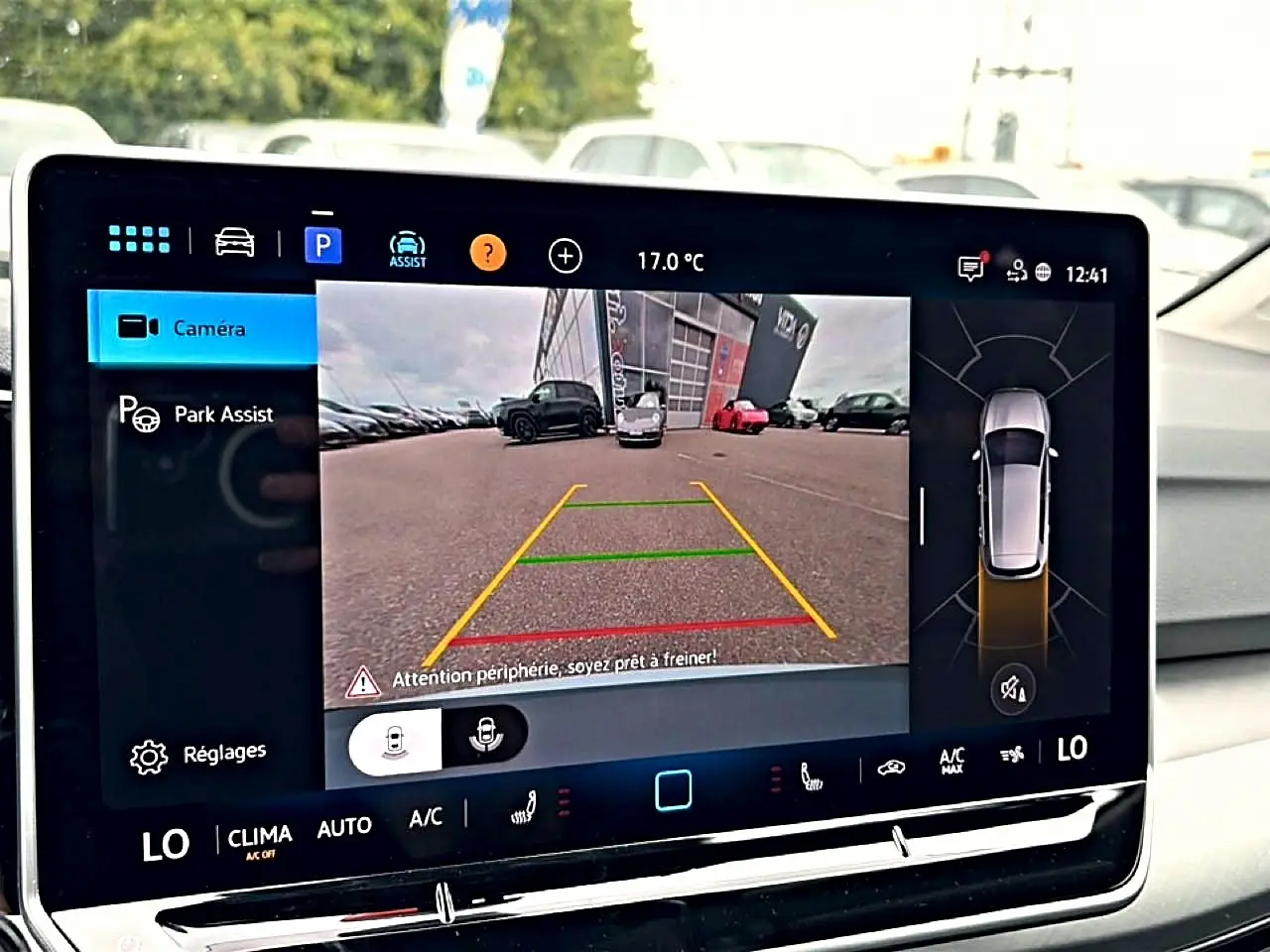 Écran tactile intérieur montrant la caméra de recul et l'assistance au stationnement du Volkswagen Golf bleu glacier 2026.