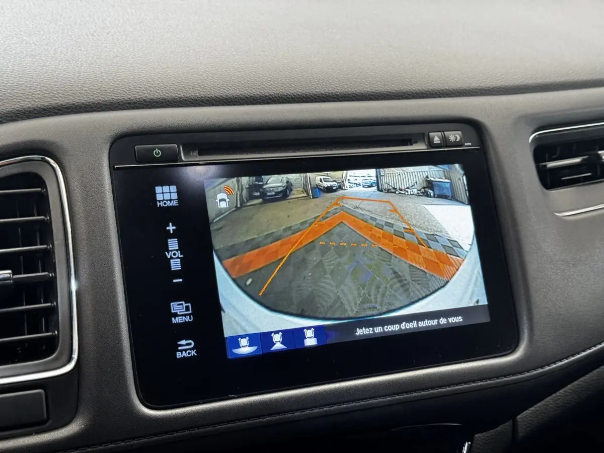 Écran tactile intérieur montrant la caméra de recul avec guidage orange sur Honda HR-V blanc, vue arrière.