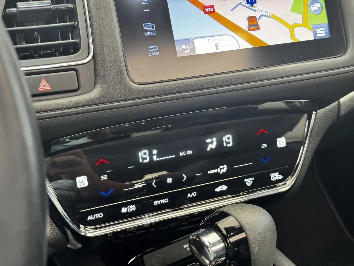 Détail de la console centrale du Honda HR-V blanc 2019, montrant l'écran tactile de navigation et la commande de climatisation digitale.