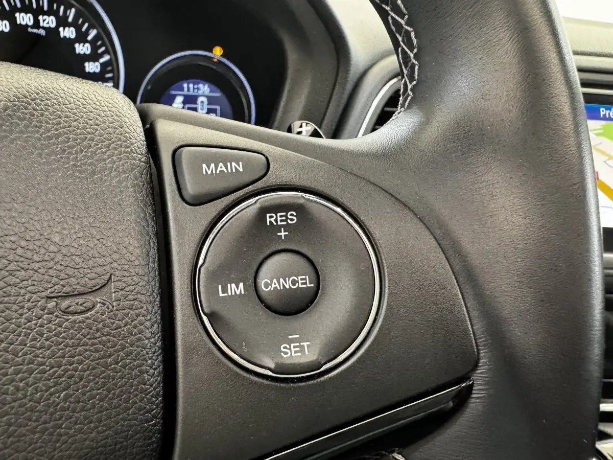 Gros plan sur les commandes du régulateur de vitesse au volant cuir noir du Honda HR-V 1.5 i-VTEC 130 Exclusive.