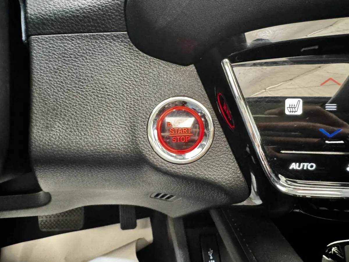 Gros plan sur le bouton rouge Start/Stop entouré de chrome dans l’habitacle noir du Honda HR-V 2019.