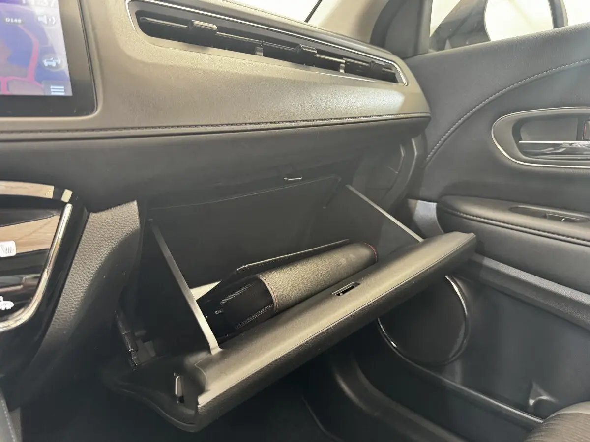 Intérieur du Honda HR-V 1.5 i-VTEC 130 Exclusive 2019, vue côté passager sur la boîte à gants ouverte noire.