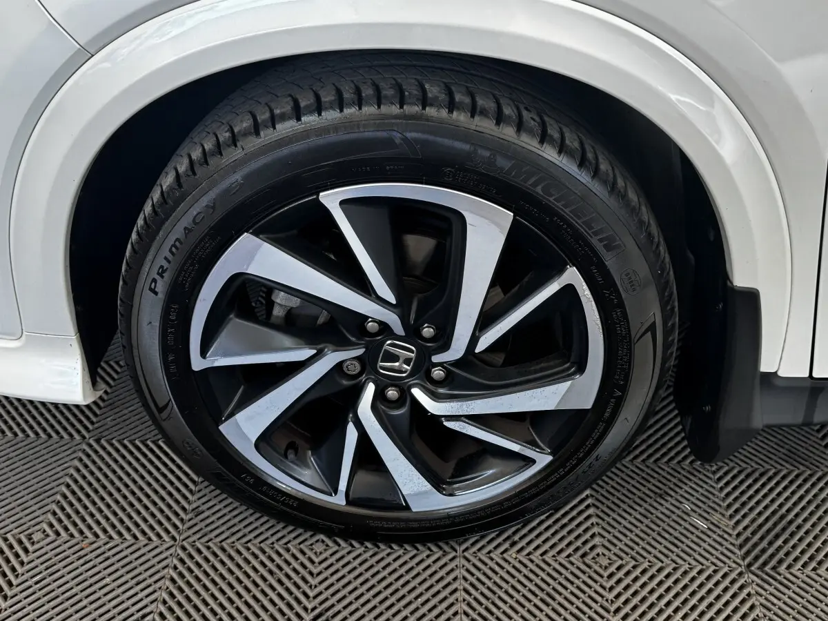 Gros plan sur la roue avant droite du Honda HR-V blanc 2019, jante alliage bicolore et pneu Michelin.