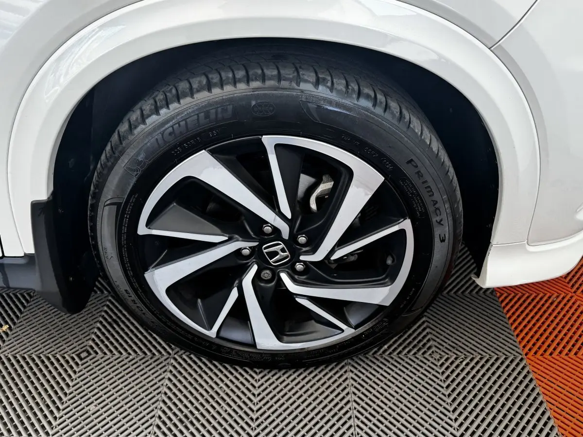 Gros plan sur la roue avant droite du Honda HR-V blanc, mettant en valeur la jante alliage bicolore et le pneu Michelin.