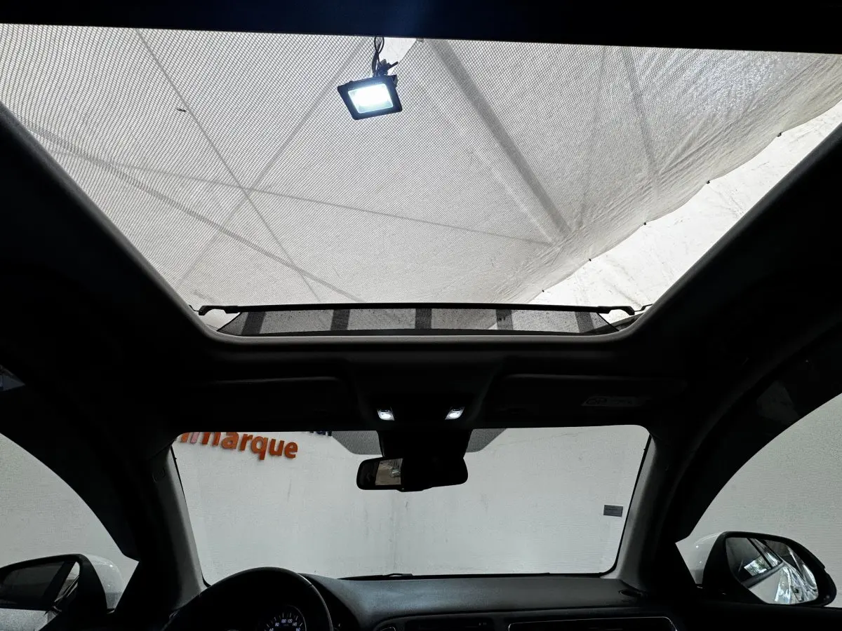 Vue intérieure du toit ouvrant électrique en verre du Honda HR-V blanc, avec tableau de bord et rétroviseurs visibles.