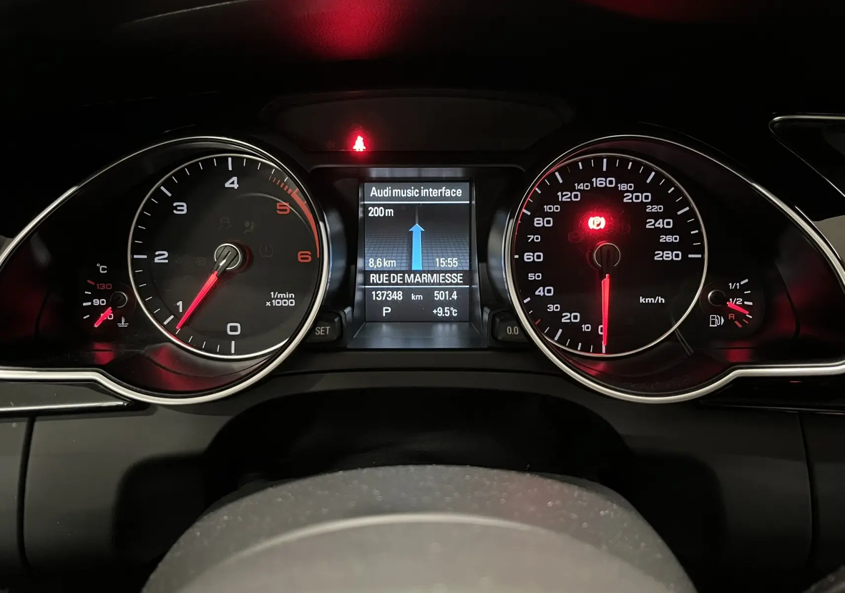 Vue rapprochée du tableau de bord noir d’une Audi A5 Sportback 2015, affichage numérique et compteurs analogiques.