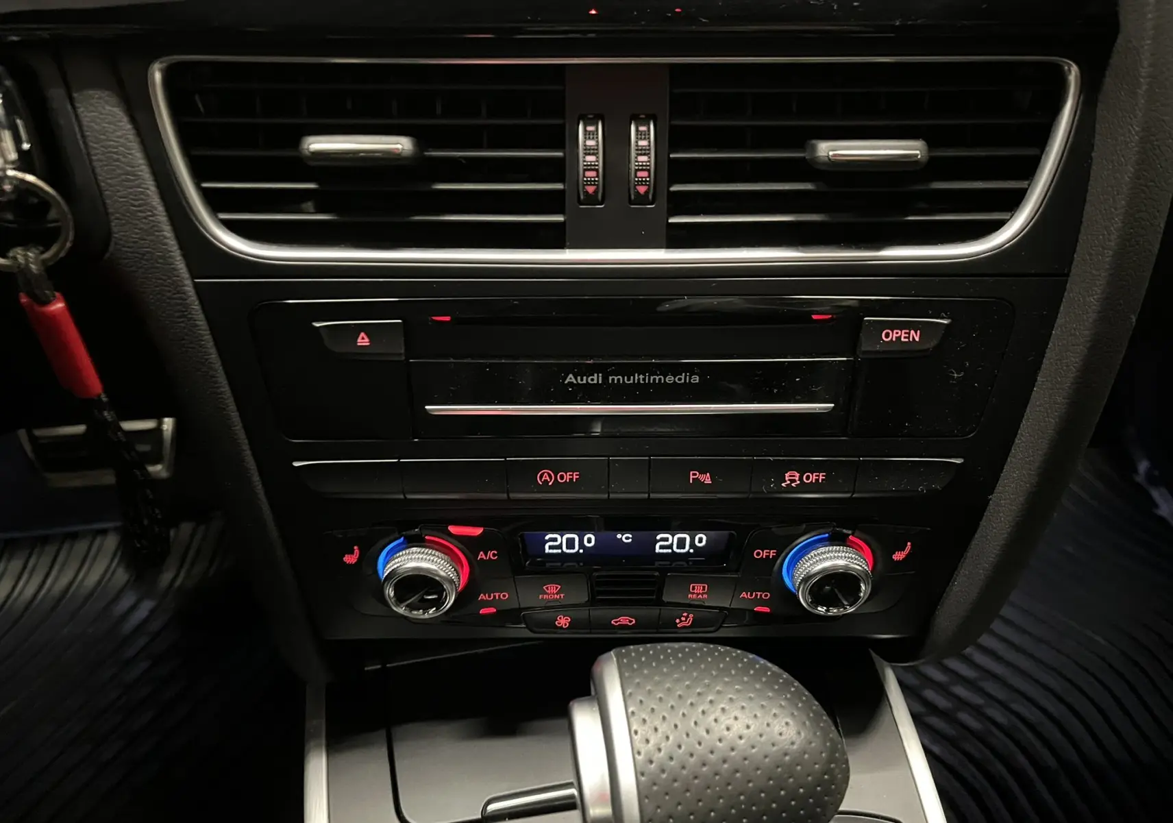 Vue rapprochée du tableau de bord central noir de l'Audi A5 Sportback avec commandes climatisation et levier de boîte auto.