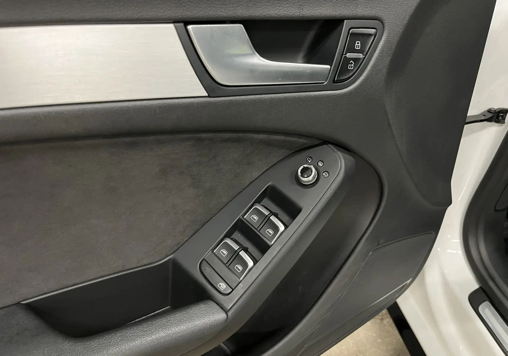 Vue rapprochée de la porte avant gauche blanche d’une Audi A5 Sportback 2015 avec commandes de vitres et verrouillage.