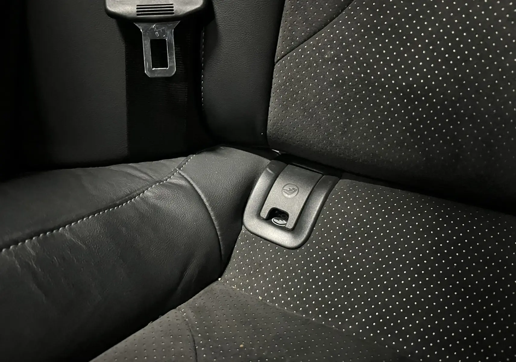 Gros plan sur la fixation ISOFIX et la ceinture noire du siège arrière en cuir et alcantara perforé de l'Audi A5 Sportback.