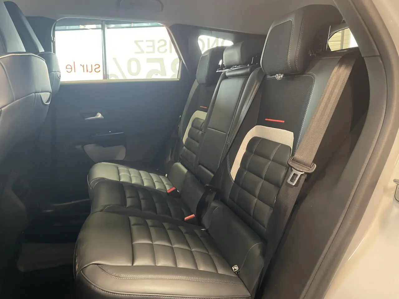 Vue intérieure côté droit des sièges arrière en cuir noir matelassé du Citroën C5 Aircross 2026 blanc Okenite.