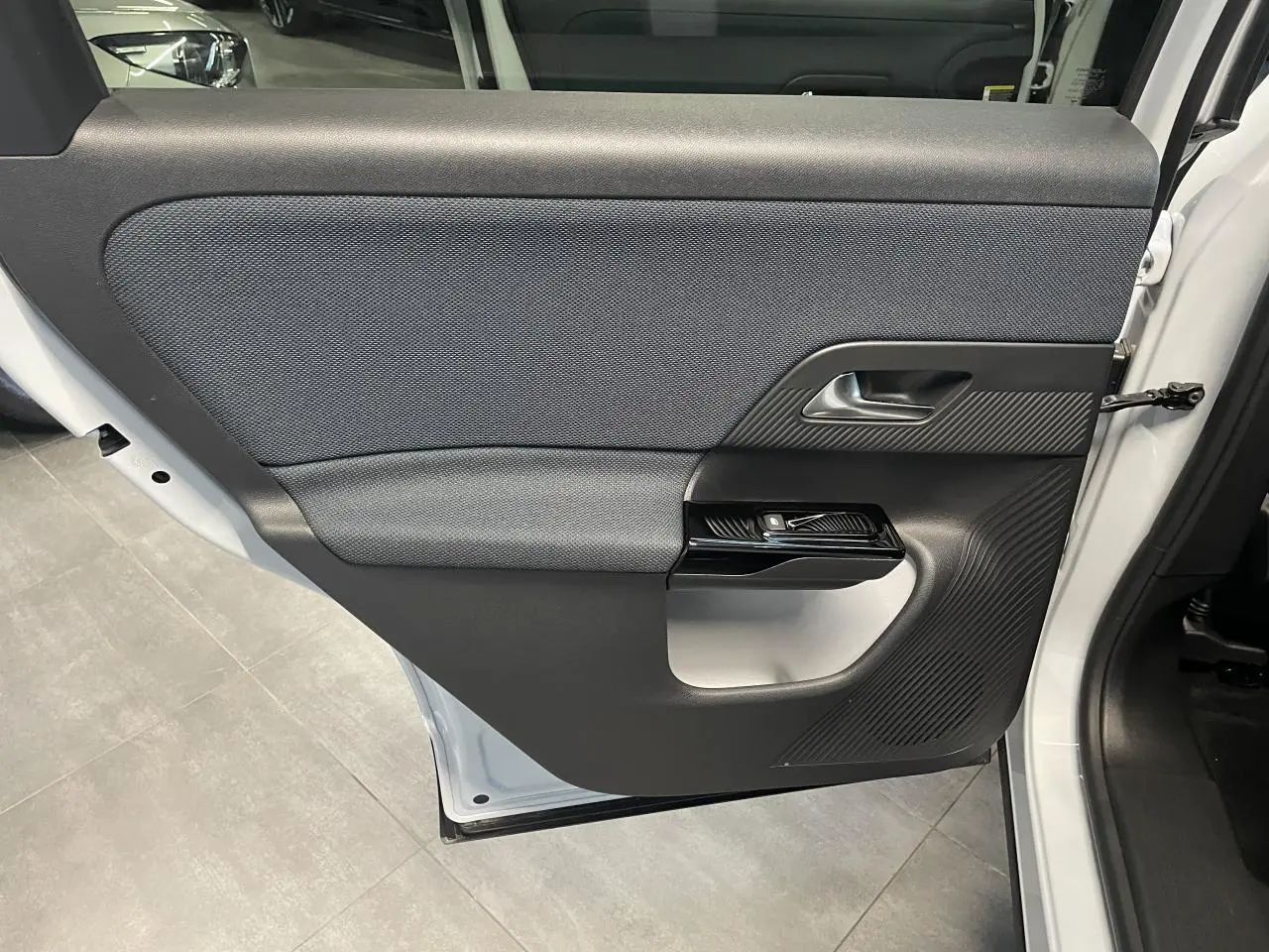 Vue rapprochée de la porte arrière droite blanche du Citroën C5 Aircross 2026 avec intérieur noir texturé.