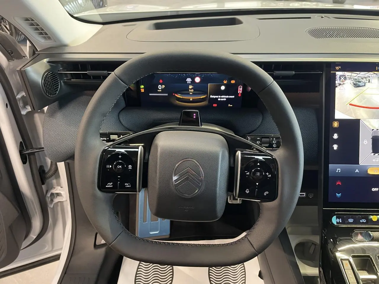 Vue intérieure centrée sur le volant noir du Citroën C5 Aircross 2026 avec tableau de bord numérique et écran tactile.