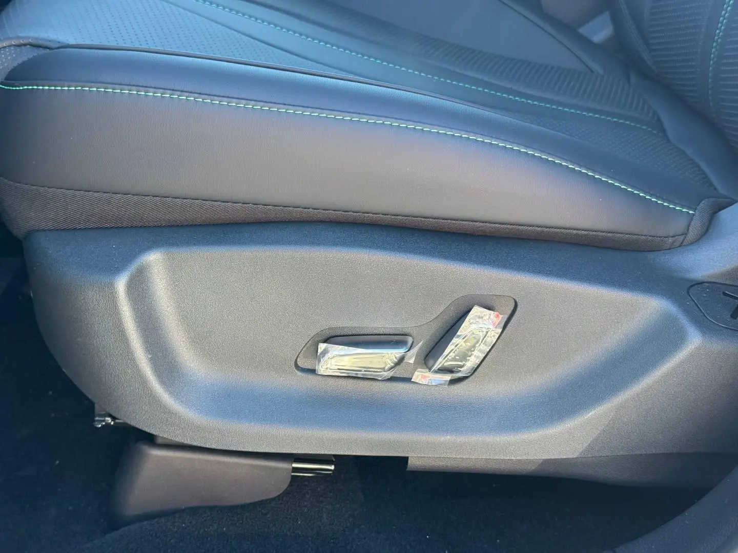 Détail du côté gauche du siège avant noir avec surpiqûres vertes du BYD SEAL U hybride rechargeable 2026.