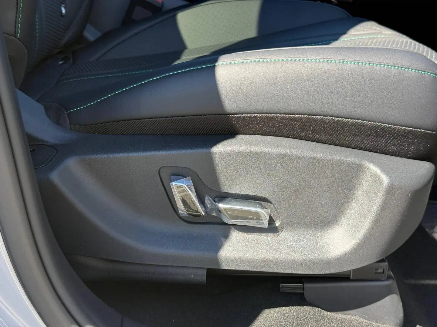 Détail du côté gauche du siège conducteur noir avec surpiqûres vertes du BYD SEAL U 2026 hybride rechargeable.