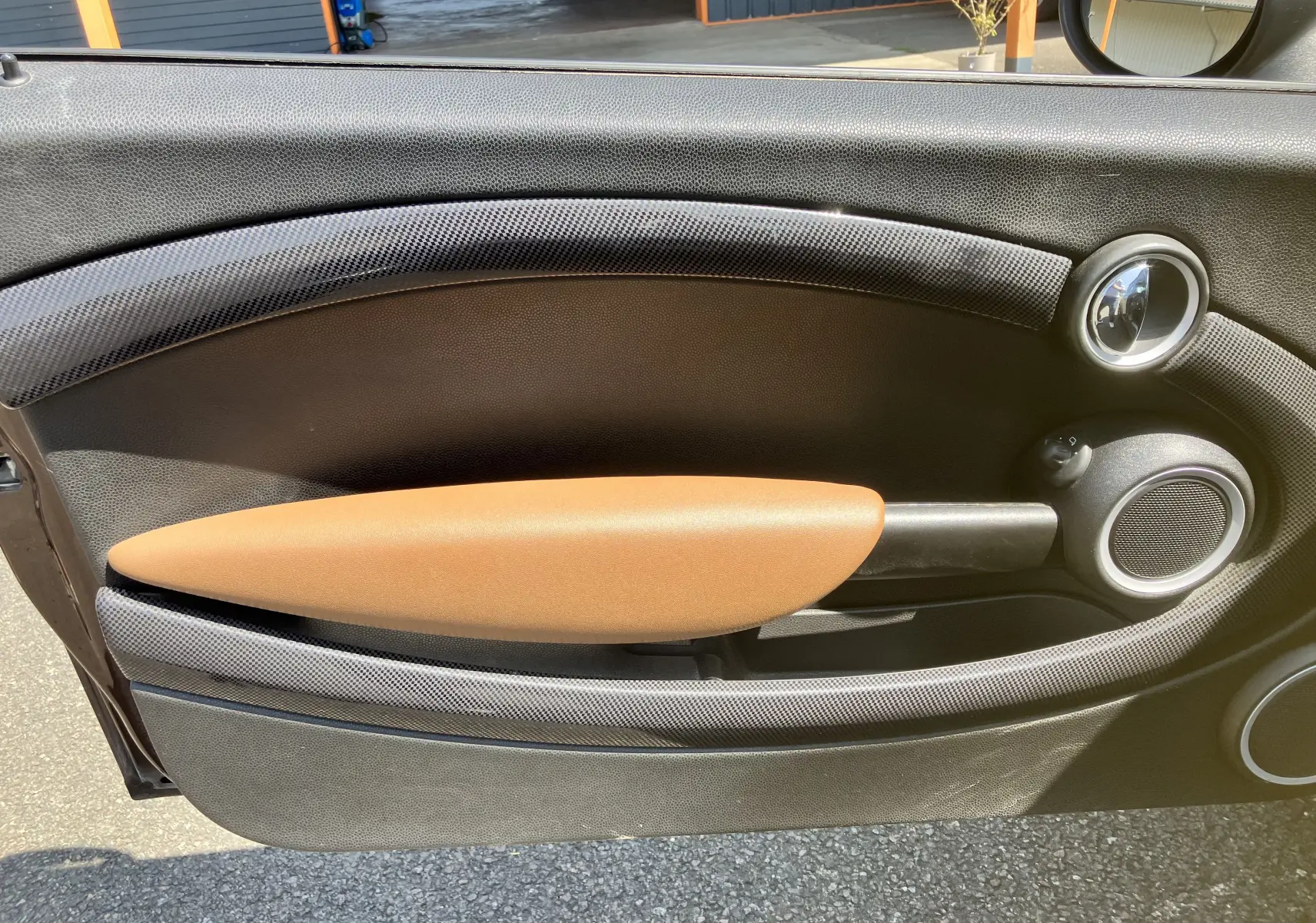 Gros plan sur la garniture intérieure marron et noire de la porte côté gauche d'une MINI Cooper S R56 de 2012.