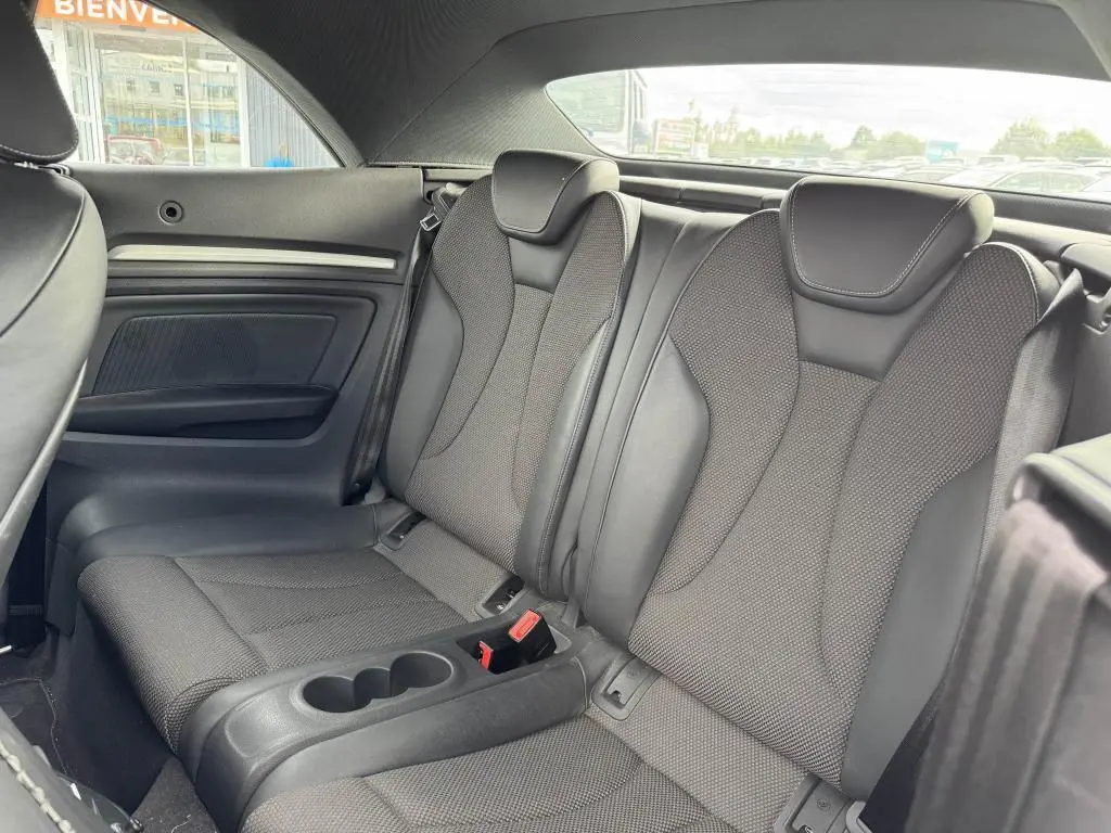 Vue intérieure arrière des sièges en tissu et cuir gris foncé de l'Audi A3 Cabriolet S Line 2019 avec accoudoir central et ceintures de sécurité.