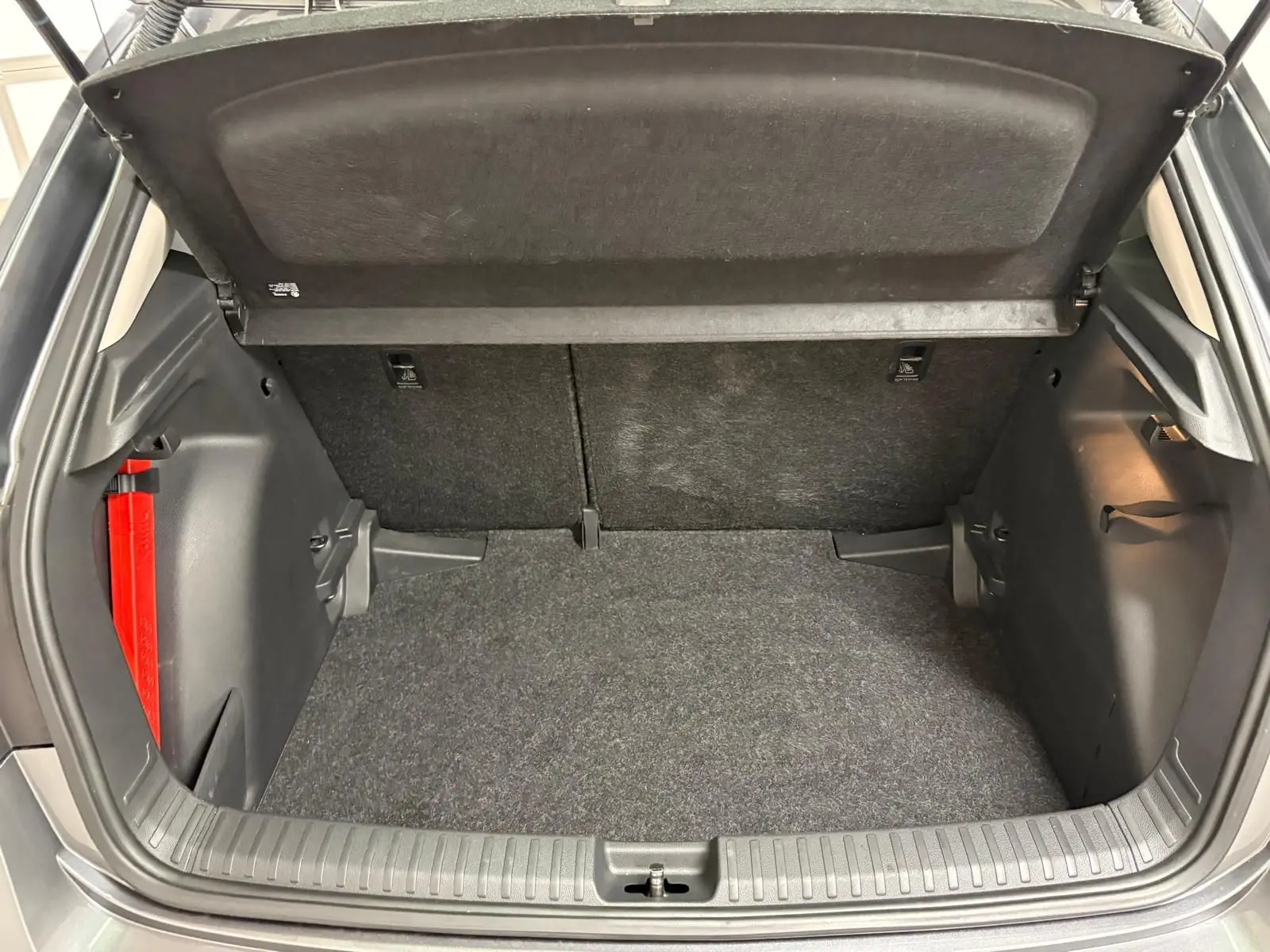 Coffre ouvert de la Skoda Fabia 2023 gris graphite, vue intérieure montrant l’espace de chargement et les garnitures noires.