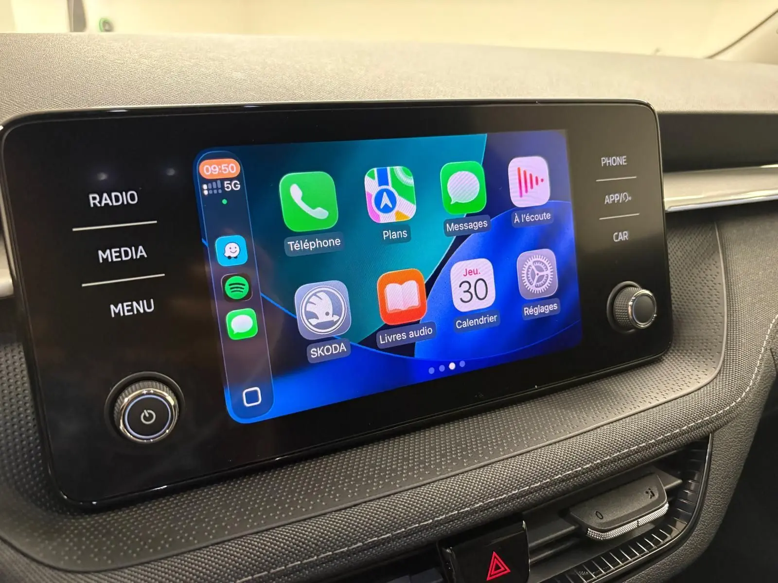 Écran tactile central de la Skoda Fabia 2023 avec interface Apple CarPlay affichée, vue de face en intérieur.