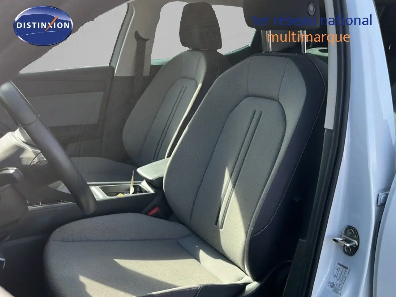 Vue intérieure côté conducteur du siège avant en tissu gris noir d'une SEAT LEON blanc neige 2025.