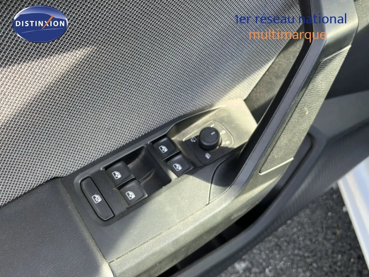 Détail des commandes de lève-vitres et rétroviseurs sur la porte côté gauche d’une SEAT LEON blanc neige 2025.