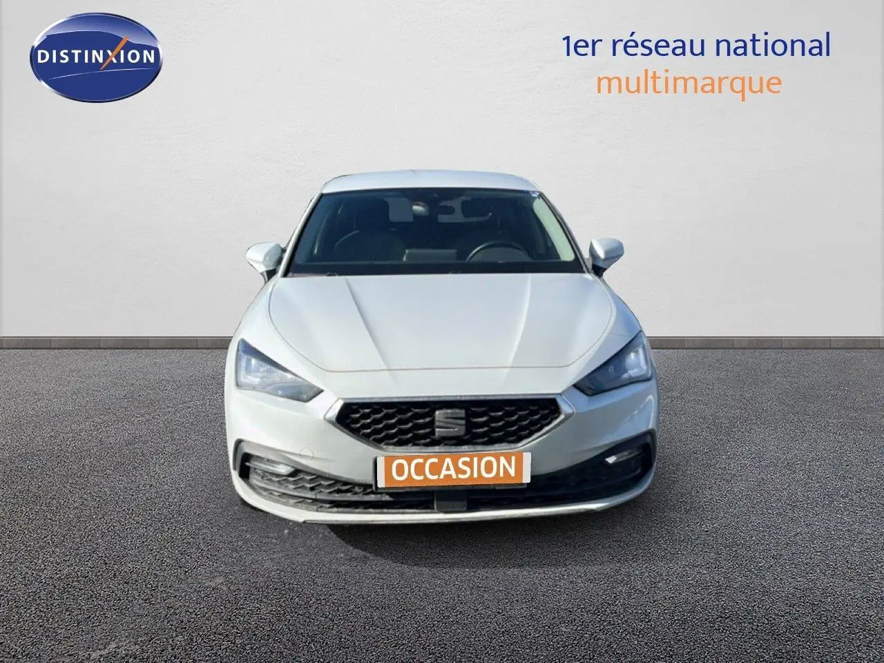 Vue frontale d'une SEAT Leon blanche neige 2025 avec calandre noire et phares LED allumés.