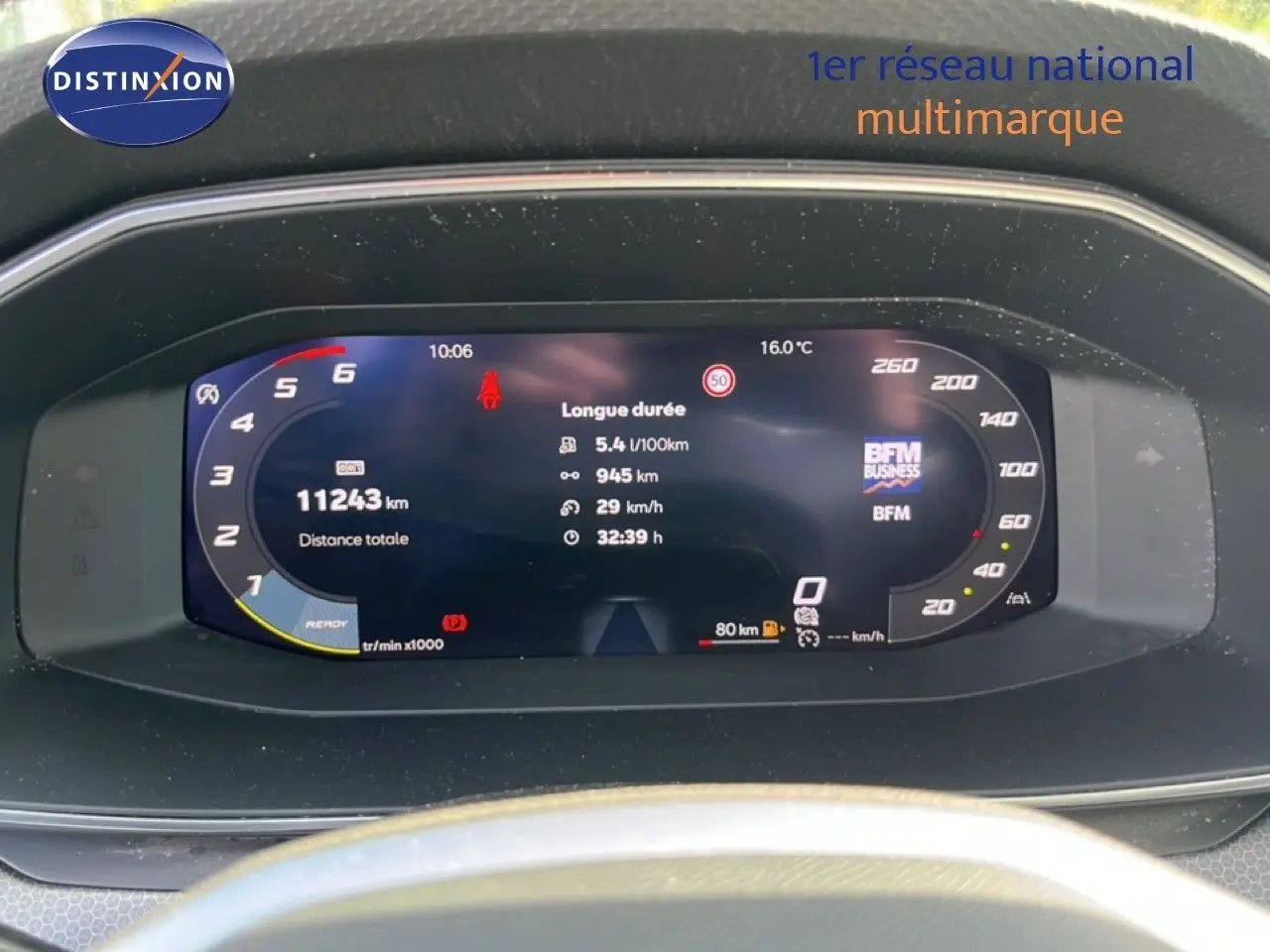 Tableau de bord numérique de la SEAT LEON blanc neige, affichant la consommation et la distance parcourue.
