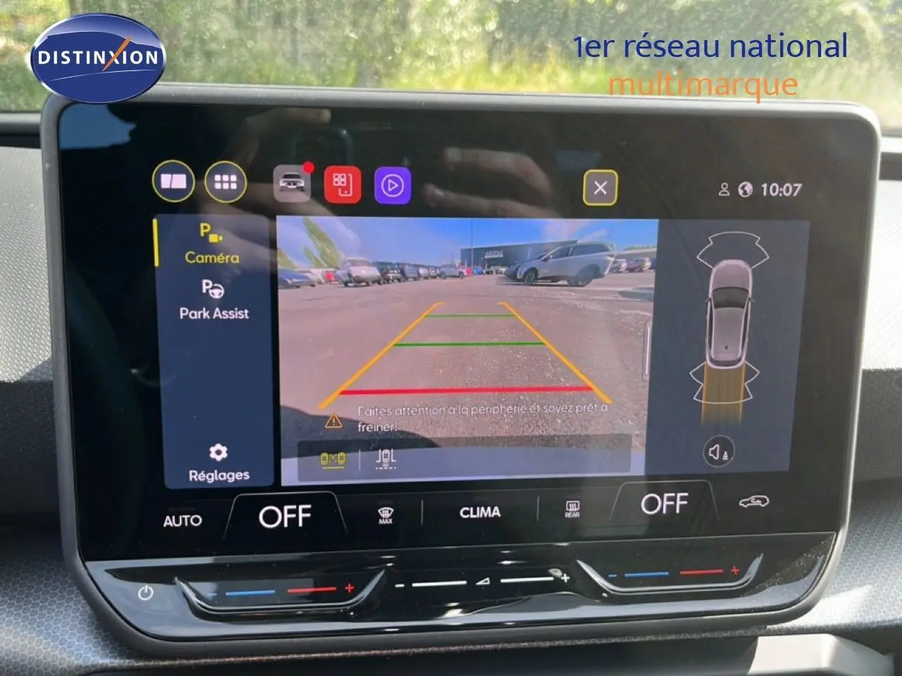 Écran tactile intérieur montrant la caméra de recul active d'une SEAT Leon blanche, vue depuis l'habitacle.