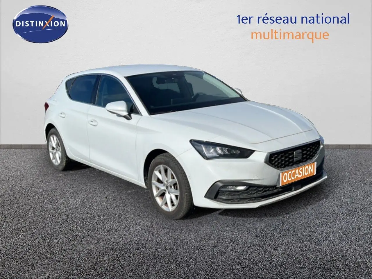 SEAT Leon blanc neige vue 3/4 avant droit, avec calandre noire et jantes alliage argentées.