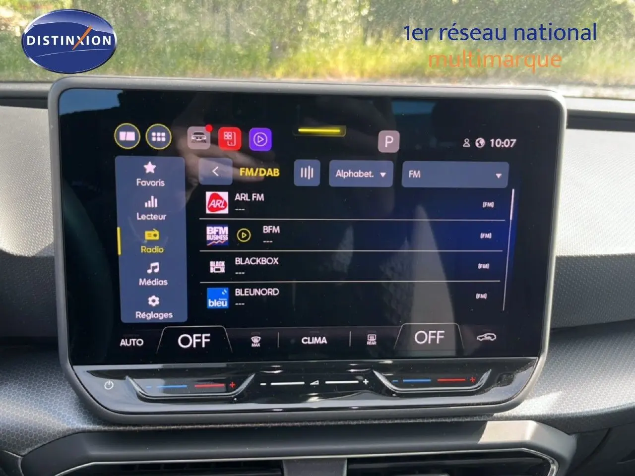 Écran tactile central affichant la radio FM dans l’habitacle d’une SEAT LEON blanc neige, vue de face.