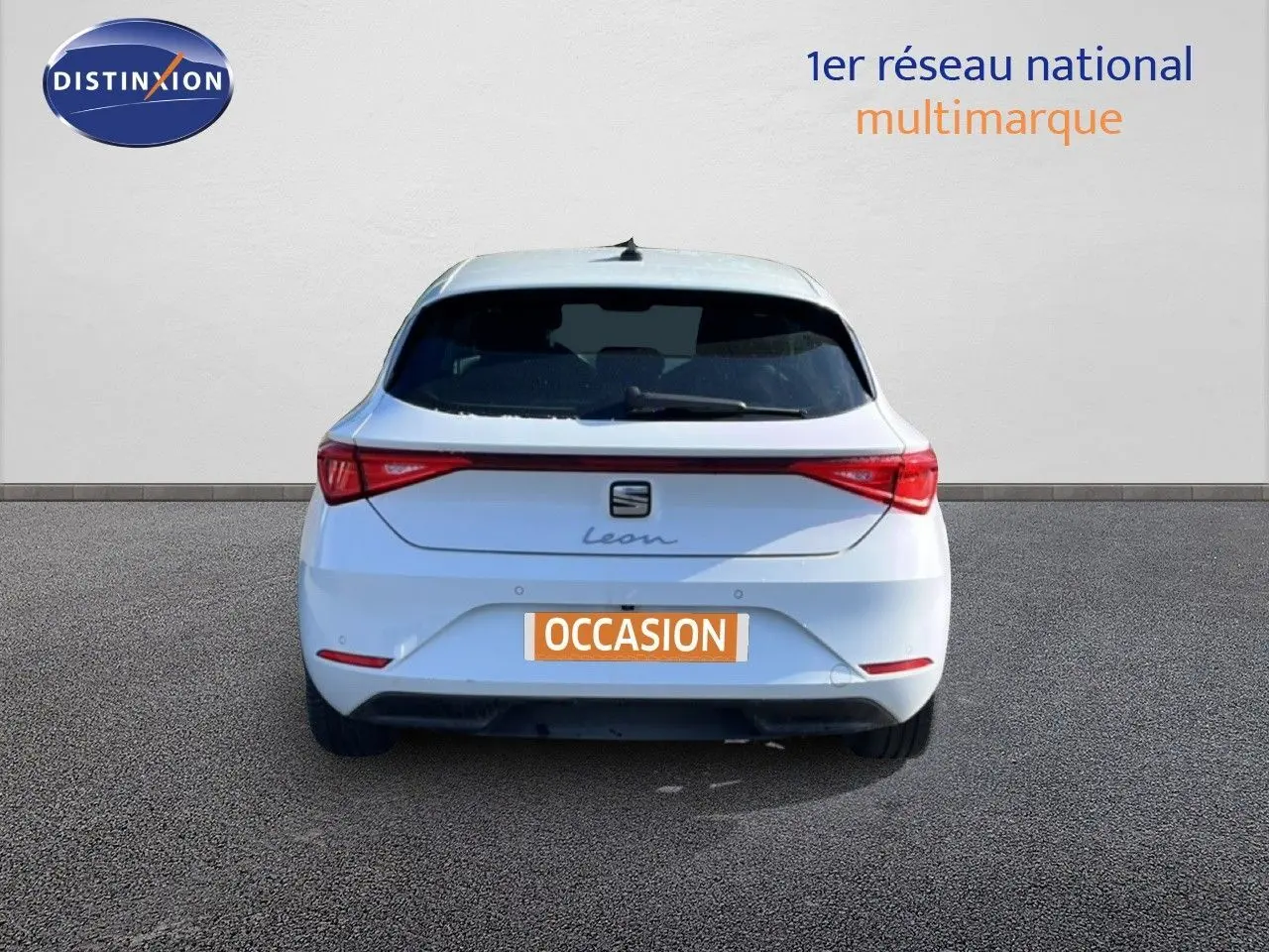 Vue arrière d'une SEAT Leon blanche neige 2025 avec feux LED et plaque d'immatriculation "OCCASION".
