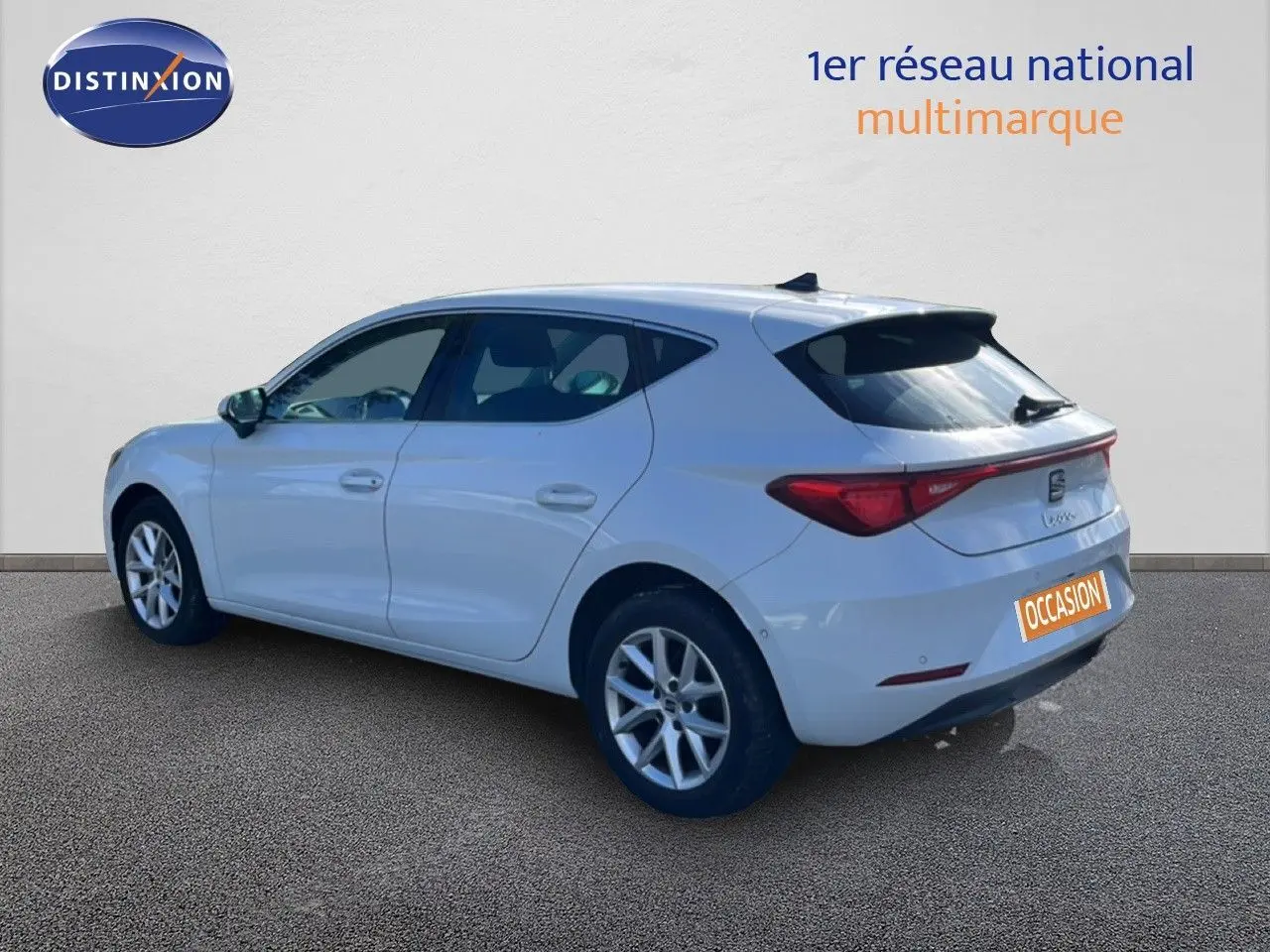 Vue 3/4 arrière droite d'une SEAT Leon blanche neige, compacte avec feux arrière LED et jantes alliage.