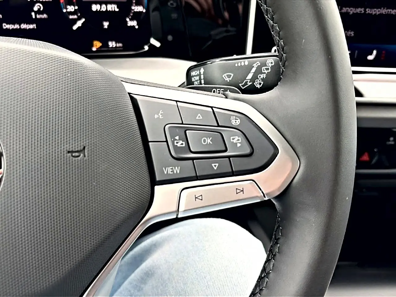 Gros plan sur le côté droit du volant noir de la Volkswagen Golf 2026, avec commandes multifonctions visibles.