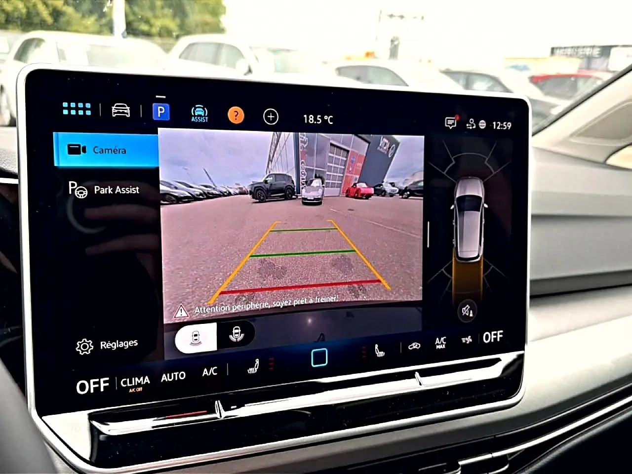Écran tactile intérieur de Volkswagen Golf noir 2026 montrant l'assistance au stationnement avec caméra de recul active.